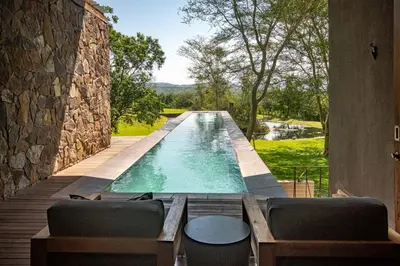 a swimming pool in the middle of a house at Summerfields Rose Retreat and Spa in Hazyview