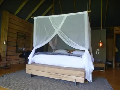 a bedroom with a bed with a canopy at Summerfields Rose Retreat and Spa in Hazyview