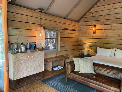 a log cabin bedroom with a bed and a couch at Summerfields Rose Retreat and Spa in Hazyview