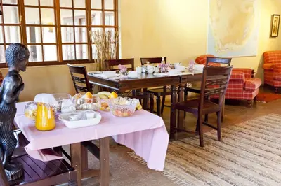 a dining room with a table with food on it at Needles Lodge in Marloth Park