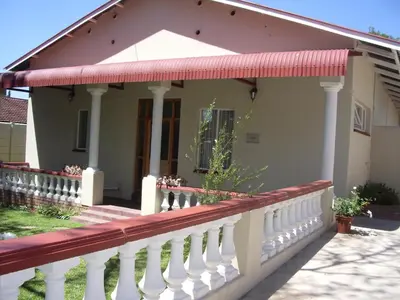 a house with a porch and a white fence at Dee's BnB in Pretoria