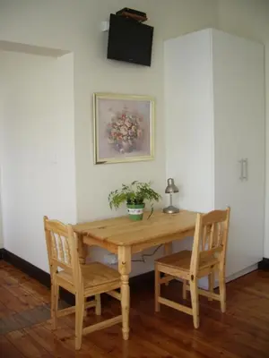 a wooden table with two chairs and a plant on it at Dee's BnB in Pretoria