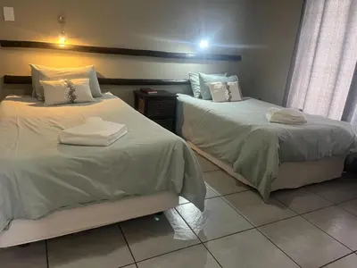 two beds sitting next to each other in a room at Leribisi Lodge in Tierpoort