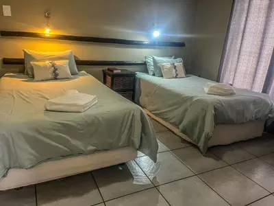 two beds sitting next to each other in a room at Leribisi Lodge in Tierpoort