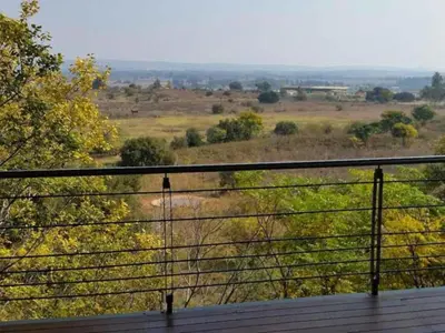 a view of a field from a balcony at Tree Tops Guest Farm in Isidule