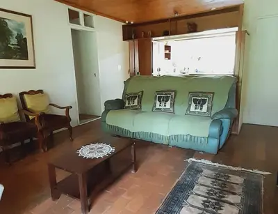 a living room with a green couch and a table at Tree Tops Guest Farm in Isidule