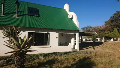 a small white building with a green roof at The Highveld Cape Inn in Pretoria