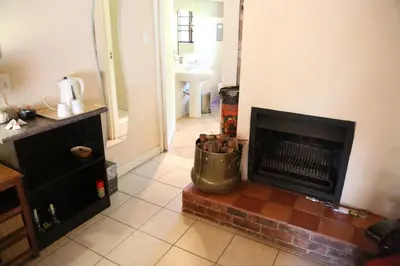 a living room with a fireplace and a sink at The Highveld Cape Inn in Pretoria
