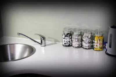 a kitchen counter with a sink and four glass jars at Serendipity NO TV in Polokwane