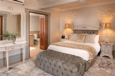 a bedroom with a large bed and a bathroom at Castello Di Monte in Pretoria