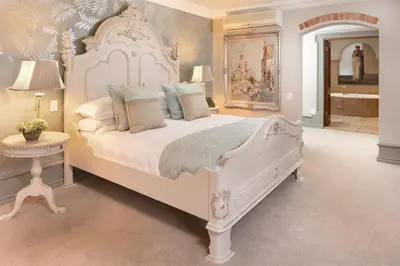 a bedroom with a large white bed in a room at Castello Di Monte in Pretoria