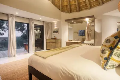 a bedroom with a large bed and a bathroom at Klaserie Drift Misava in Klaserie Private Nature Reserve