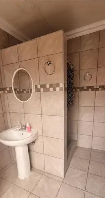 a bathroom with a sink and a mirror at Stay at Home Airport Lodge in Kempton Park