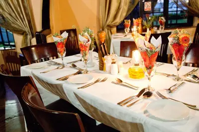 a table with white tablecloths and utensils on it at Lalapanzi Hotel & Conference Centre in Bandelierkop
