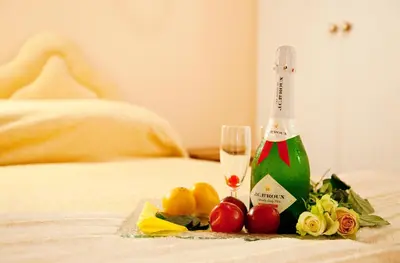 a bottle of champagne and fruit on a bed at Lalapanzi Hotel & Conference Centre in Bandelierkop