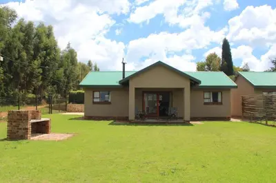 a small house with a green roof on a yard at Misty Cottage in Dullstroom