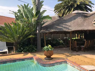 a house with a pool with a thatch roof at Annie's Place in Kempton Park