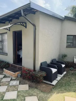 a house with two couches in front of a house at Annie's Place in Kempton Park