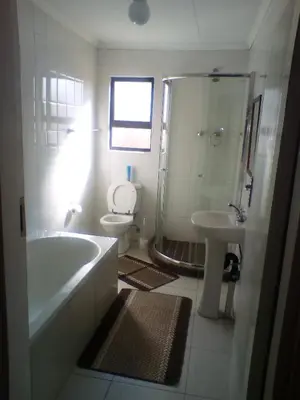 a bathroom with a tub and a toilet and a sink at Mmakosha Lodge in Pretoria