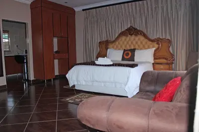 a hotel room with a bed and a couch at Mmakosha Lodge in Pretoria