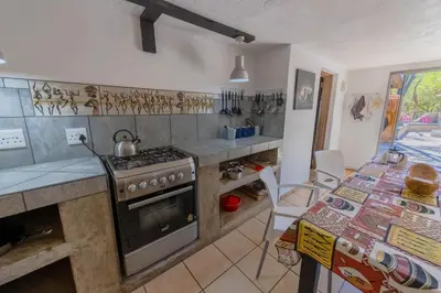 a kitchen with a stove and a table with a table at African Sky Villas in Marloth Park