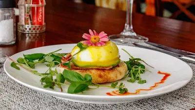 a white plate with a dessert with a flower on it at Christies at 32 on Russell in Nelspruit