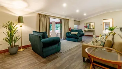 a living room with two chairs and a couch at Christies at 32 on Russell in Nelspruit