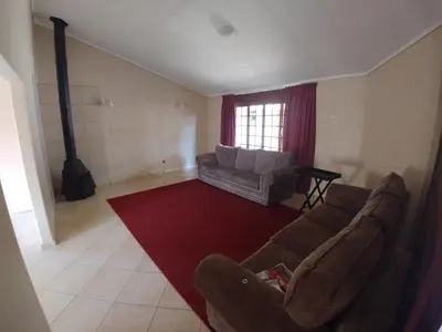 a living room with a couch and a red rug at 22 on Nicol in Secunda