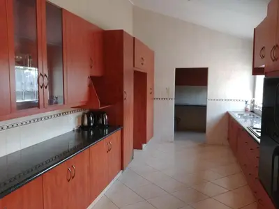 a kitchen with wooden cabinets and black counter tops at 22 on Nicol in Secunda