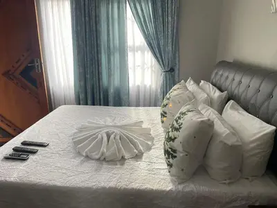 a bed with white sheets and pillows in a bedroom at Dreamwood Guest House in Nelspruit