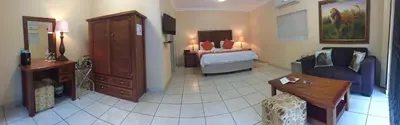 a room with a bedroom with a bed and a couch at Ubuntu Bed and Breakfast in Marloth Park