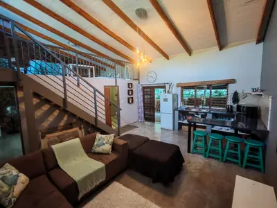 a living room with a couch and a kitchen at Arend Cottage in Nelspruit