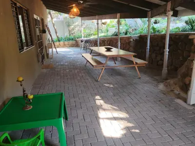 a patio with a table and a green table at Arend Cottage in Nelspruit