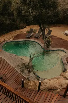 a swimming pool on a deck with two lounge chairs at Panzi Lodge in Guernsey Nature Reserve