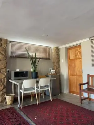 a kitchen with a table and chairs and a microwave at 7th Hole Golf Lodge in Modimolle