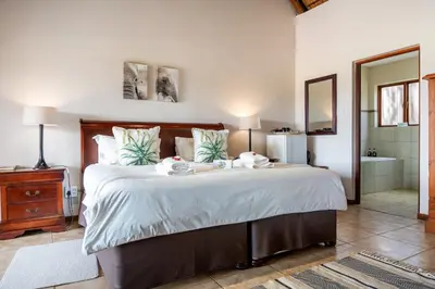 a bedroom with a large bed with two towels on it at 7th Hole Golf Lodge in Modimolle