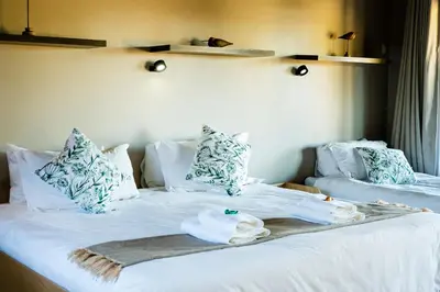 a bedroom with two beds with towels on them at 7th Hole Golf Lodge in Modimolle