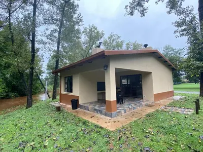 a small house in the middle of a field at Merry Pebbles Resort in Sabie