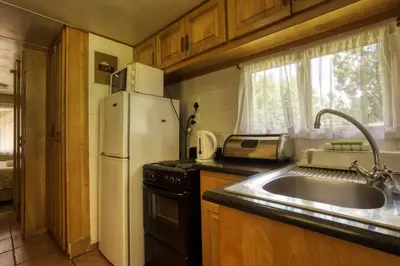 a kitchen with a white refrigerator and a sink at Merry Pebbles Resort in Sabie