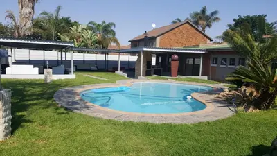 a swimming pool in the yard of a house at Savannah Guest House in Polokwane