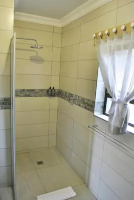 a bathroom with a shower with a glass door at Christie's Inn in Tzaneen