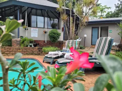a patio with two chairs and a pool at Christie's Inn in Tzaneen