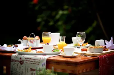a table with plates of food and glasses of orange juice at Christie's Inn in Tzaneen
