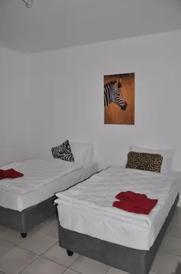 two beds in a room with a picture of a zebra at Hazyview Buffalo Game Lodge in Hazyview