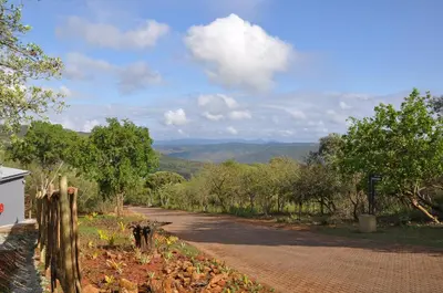 a dirt road with a fence on the side at Hazyview Buffalo Game Lodge in Hazyview