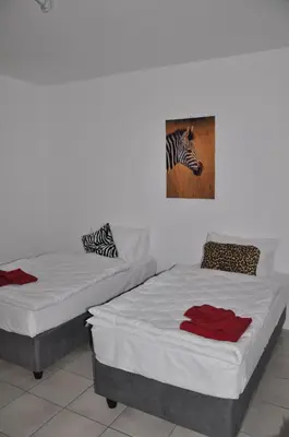 two beds in a room with a picture of a zebra at Hazyview Buffalo Game Lodge in Hazyview