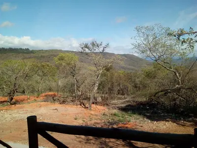 a view of a hill with trees and a fence at Hazyview Buffalo Game Lodge in Hazyview