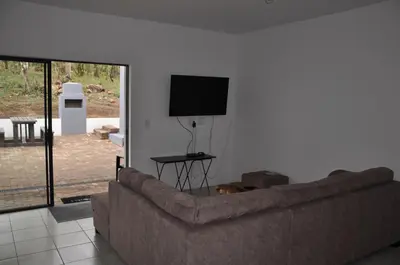 a living room with a couch and a flat screen tv at Hazyview Buffalo Game Lodge in Hazyview