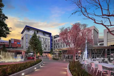 a building with tables and chairs on a city street at Protea Hotel by Marriott Pretoria Loftus Park in Pretoria
