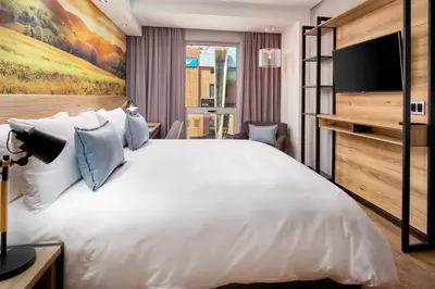 a bedroom with a large white bed and a flat screen tv at Protea Hotel by Marriott Pretoria Loftus Park in Pretoria